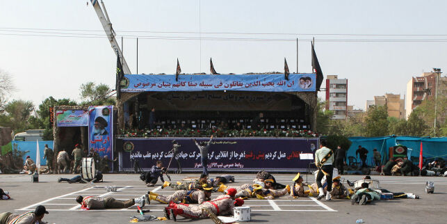 TOPSHOT - This picture taken on September 22, 2018 in the southwestern Iranian city of Ahvaz shows injured soldiers lying on the ground at the scene of an attack on a military parade that was marking the anniversary of the outbreak of its devastating 1980-1988 war with Saddam Hussein's Iraq. - Eleven people were killed including a journalist and more than 30 wounded in an attack on September 22 on an army parade in southern Iran, according to the latest toll by the semi-official news agency ISNA. (Photo by ALIREZA MOHAMMADI / ISNA / AFP)